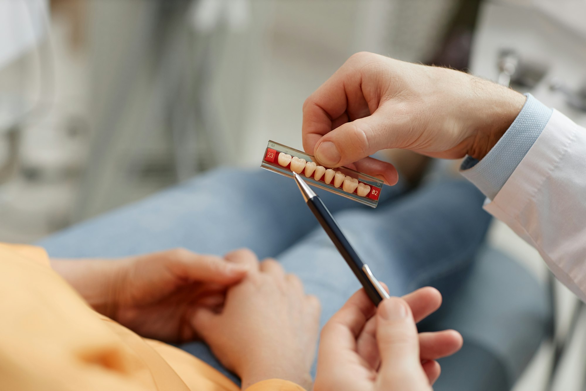 Dentist pointing at tooth prosthetics for dental implantation surgery